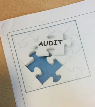 Een puzzelstuk met het woord audit